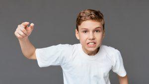niño se muestra amenazante levantando su puño por tener problemas de conducta