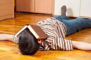 Niño con TDAH descansando con un libro tapando su cara