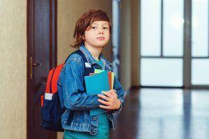 vuelta al cole de un niño que va con mochila y cuadernos