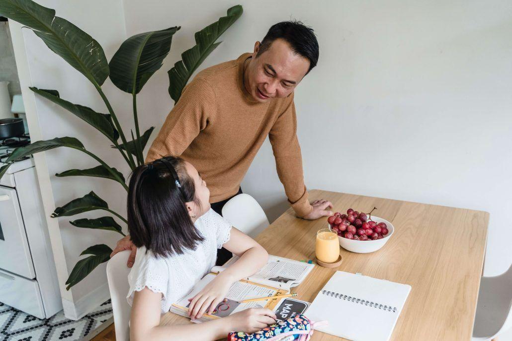 padre ayudando a su hija con sus deberes para que tenga buena comprensión lectora