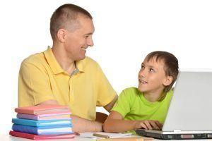 niño con su padre delante del ordenador trabajando la comprensión lectora