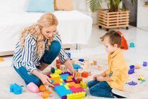 una madre juega con su hijo con un trastorno del lenguaje a las construcciones