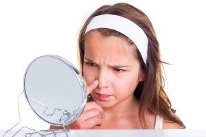 adolescente mirándose al espejo y juzgando si es guapa